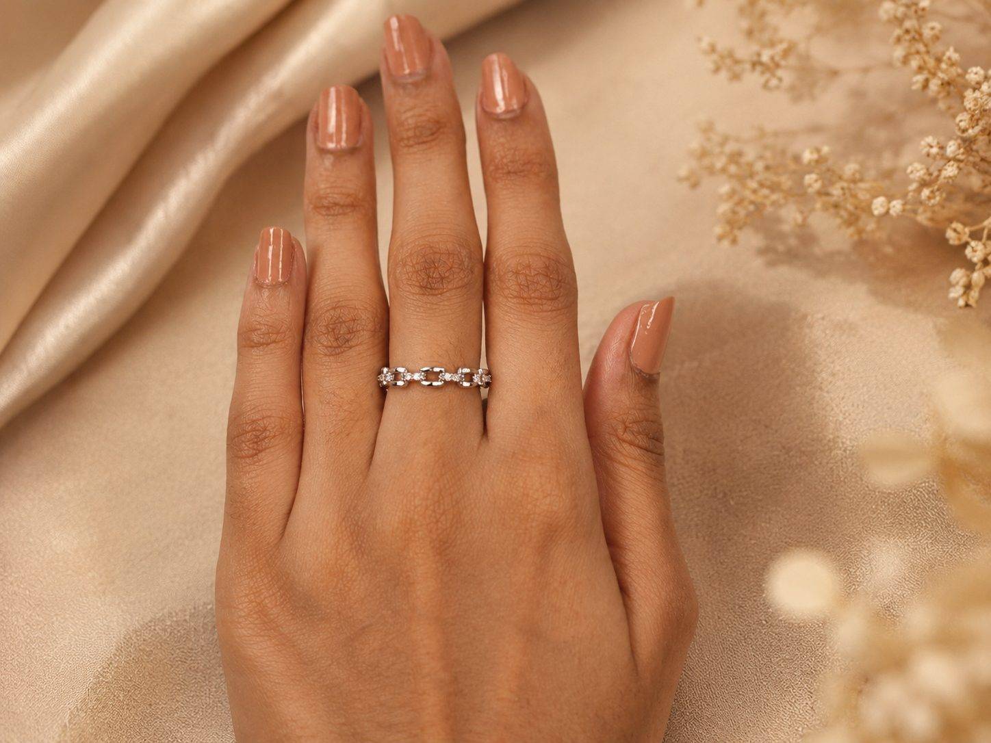 Features interlocking links styled as a chain with pavé-set stones.