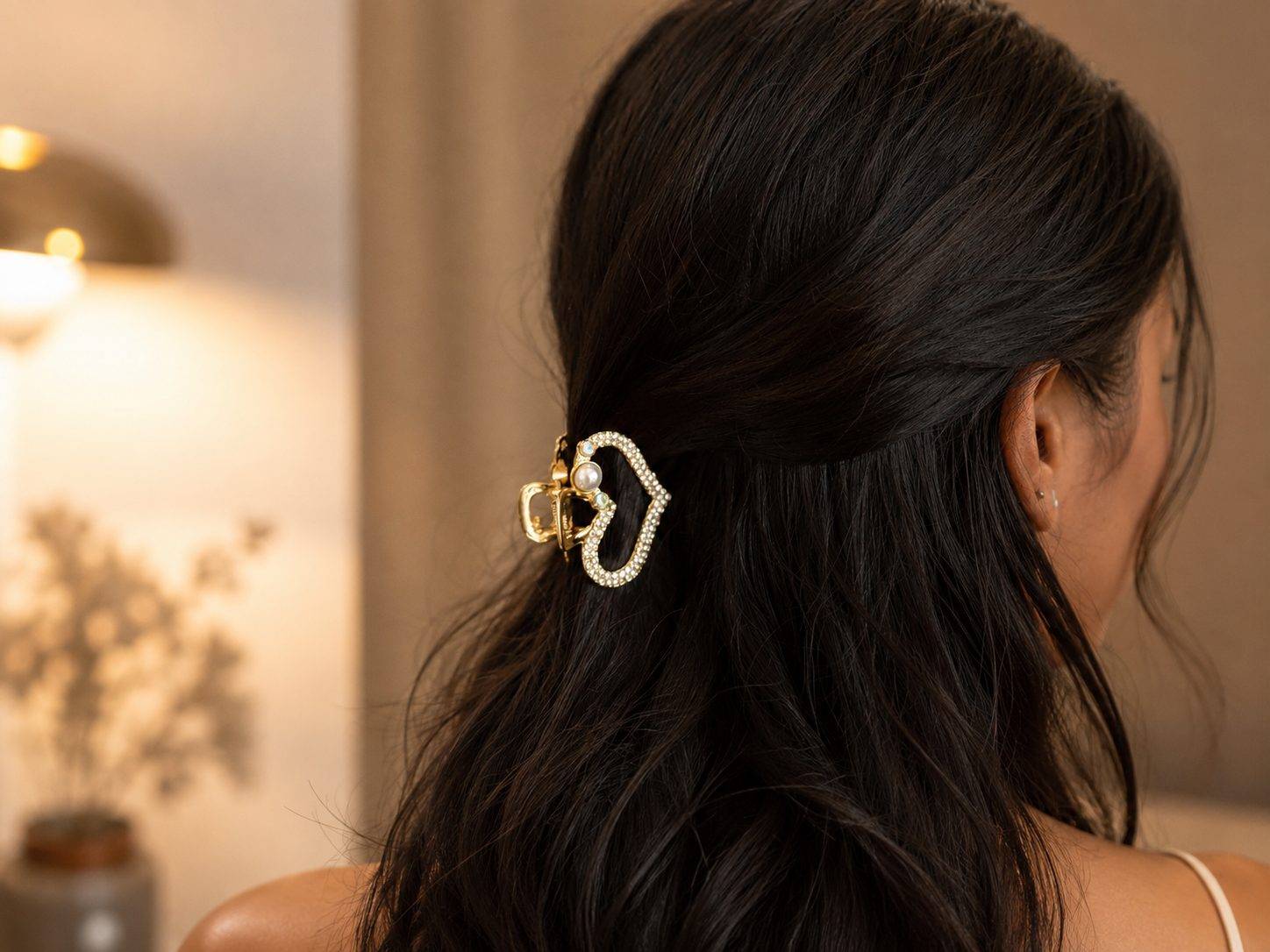 Heart-shaped claw clip is embellished with rhinestones and a central faux pearl.