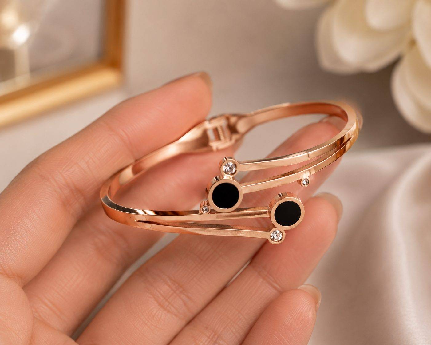 Rose gold bracelet features a modern, geometric design with distinctive black circular accents.