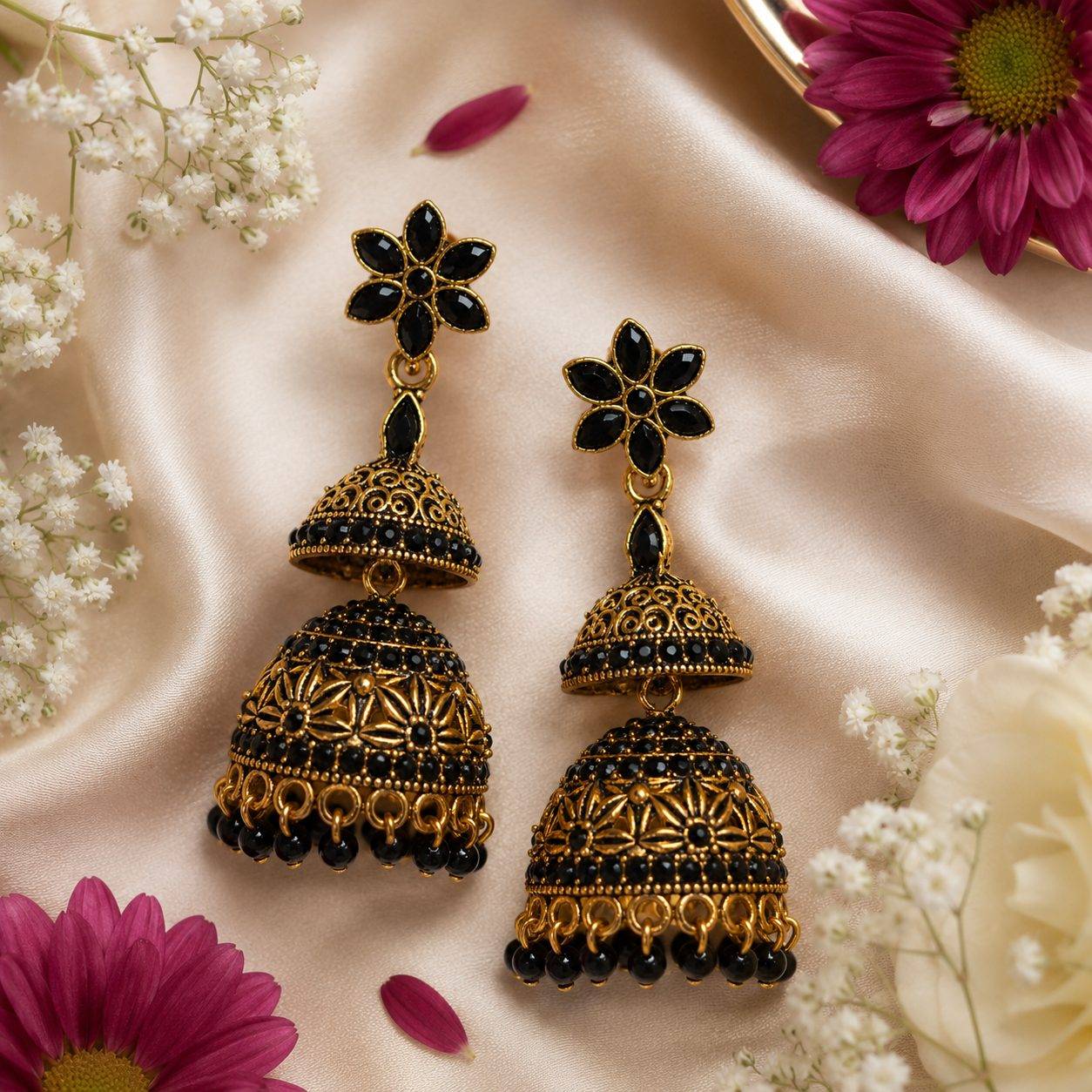 antique gold-plated floral jhumka earrings featuring black crystal stone embellishments and beaded fringe drops
